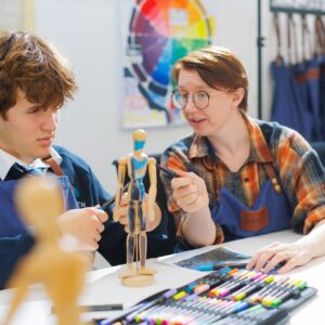 A teacher working with students in an art lesson